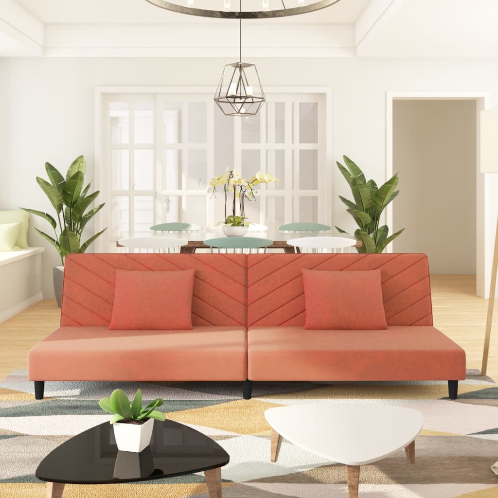 2-seater sofa bed with two pink velvet cushions